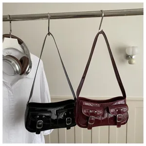 Patent leather shoulder bag with dual front pockets, chic baguette handbag for women.