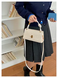 Woven crossbody bag for women, stylish shoulder bag with top handle and metal lock.