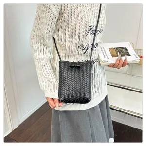 Black woven PU leather crossbody phone bag with horn buckle, stylish mini shoulder bag detail.