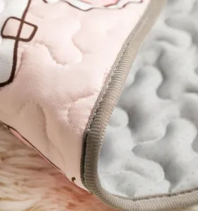 Close-up detail of soft pet sleeping mat showing quilted pink fabric and anti-slip backing.