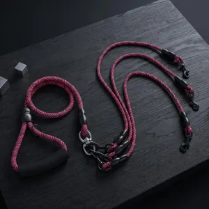 Detailed view of the multi dog leash featuring a braided pink and black rope and durable metal hooks.