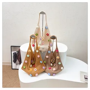 Détails du sac cabas tricoté main avec des fleurs colorées crochetées et une texture douce.