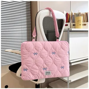 Pink quilted laptop bag detail, featuring cute blue bow embroidery and durable nylon fabric.