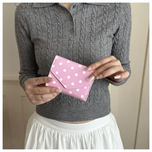 Dettaglio portafoglio a pois rosa, piccola borsa per monete carina con patta per uso quotidiano.