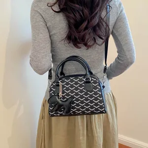 Stylish women crossbody handbag with chevron pattern and cute dog pendant for daily commute.