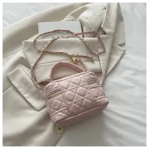 Pink quilted vanity bag detail showcasing intricate stitching, chain strap and elegant hardware.
