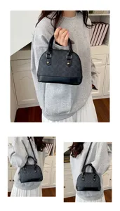 Detail view of the stylish monogram dome handbag in black, showing versatile carrying options.