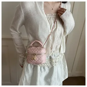 Detailed view of the stylish pink quilted vanity bag with metal chain strap and top handle.