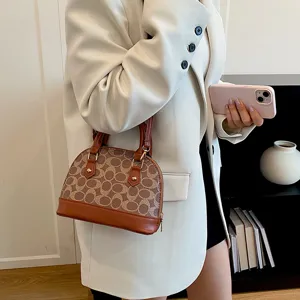 Detailed close-up view of the women monogram dome handbag with brown leather trim and handle.