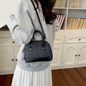 Classic black dome shoulder bag with C monogram pattern, top handle and crossbody strap for women.