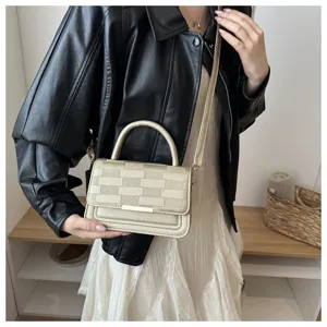 Vue détaillée de l'élégant sac à bandoulière doré à carreaux avec une texture fine.