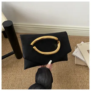 Elegant black evening clutch bag with statement gold metal handle for women chic party.