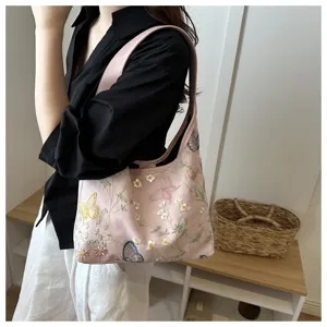 Detalle de bolso de hombro hobo bordado rosa, elegante diseño floral de encaje en media luna.