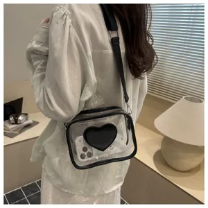 Vue détaillée du sac bandoulière transparent en PVC avec cœur noir et large sangle élégante.
