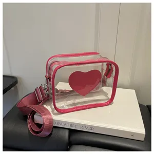 Sac bandoulière transparent avec bordure rose et détail de cœur, sac élégant pour femme.