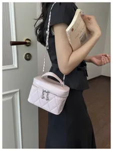 Sac bandoulière matelassé rose avec bandoulière chaîne et poignée, vue détaillée du style chic.