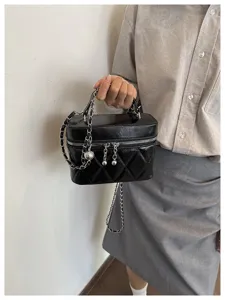 Vue rapprochée et détaillée du sac bandoulière matelassé noir avec des ferrures élégantes.