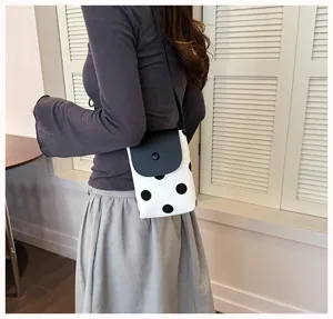 Chic black and white polka dot crossbody phone bag detail view, stylish summer accessory.