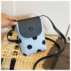 Detail shot of mini crossbody phone bag, light blue polka dot canvas with black flap.