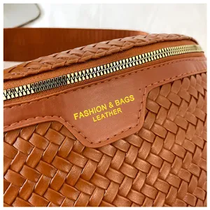 Vue détaillée d'un sac à bandoulière en cuir tressé marron tendance avec fermeture éclair.