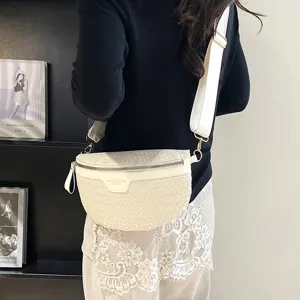 Vue détaillée du sac bandoulière tressé blanc, mettant en valeur texture et large sangle.