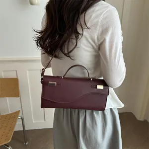 Gedetailleerd overzicht van de elegante bordeauxrode PU lederen handtas met metalen details.