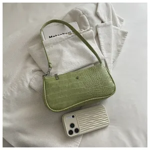 Vue detaillee du sac baguette epaule en crocodile vert, mettant en valeur les finitions.