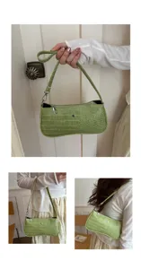 Gros plan détaillé du sac porté épaule vert clair effet croco avec fermeture éclair métallique.