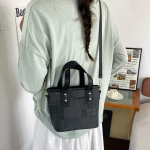 Black patterned bucket bag, chic shoulder and crossbody design, versatile daily fashion accessory.