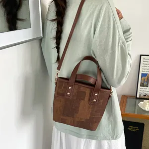 Detail view showing the stylish brown patterned bucket bag with durable leather handle.