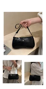 Vue rapprochée du sac porté épaule baguette à motif crocodile noir avec pendentif croix.