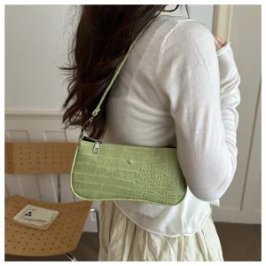 Vue détaillée du sac porté épaule motif crocodile vert, élégant sac baguette pour femme.
