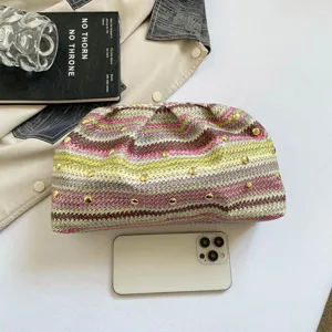 Vue rapprochée de la pochette tissée colorée montrant les détails de rivets métalliques.