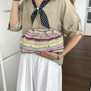 Sac pochette arc-en-ciel tissé main avec rivets métalliques, fourre-tout de plage chic pour femmes.