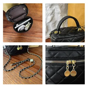 Detail view of black quilted box bag featuring gold hardware, chain strap and secure zipper.