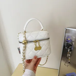 Detailed view of the white quilted vanity bag with golden chain strap and hardware.