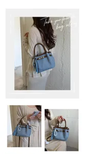 Denim handbag detail view featuring brown leather trim, metal turn-lock closure, and pearl charm.