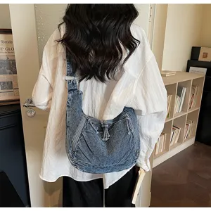 Retro washed denim crossbody dumpling bag with zip pockets and spacious casual commuting design.