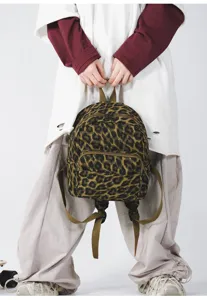 Vista dettagliata in primo piano dello zaino alla moda con stampa leopardata e doppie cerniere.