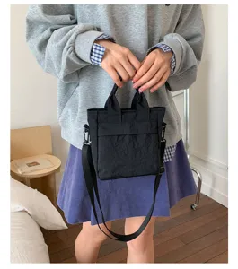 Gedetailleerd overzicht van de zwarte casual canvas handtas met stevige stof en riemen.