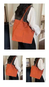 Vista dettagliata della grande borsa tote in tela arancione con tasche multiple.