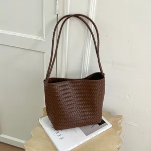 Retro woven leather shoulder bag for women, chic casual bucket bag with slim straps.