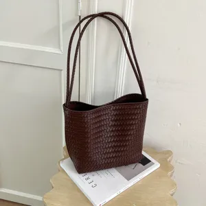Dark brown woven leather shoulder bag detail, stylish minimal design accessory for women.