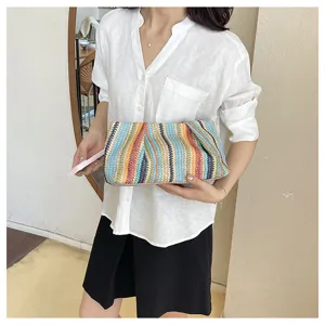 Colorful straw woven clutch bag detail view, fashion summer beach vacation accessory.