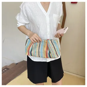 Detail shot of colorful woven straw clutch bag, stylish summer beach handbag for casual daily wear.
