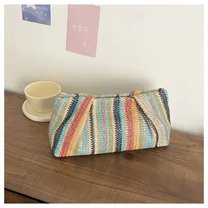 Detailed view of colorful woven straw clutch bag, perfect summer beach fashion accessory.