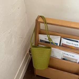 Chic green woven leather bucket bag with stylish texture and versatile crossbody wear.