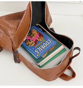 Retro brown leather backpack detail showing spacious interior and crocodile PU texture.