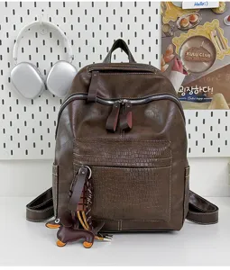 Detail view of the vintage brown PU leather backpack featuring front crocodile texture pocket.