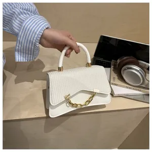 Chic white top handle handbag for women, featuring trendy curved flap and gold chain detail.